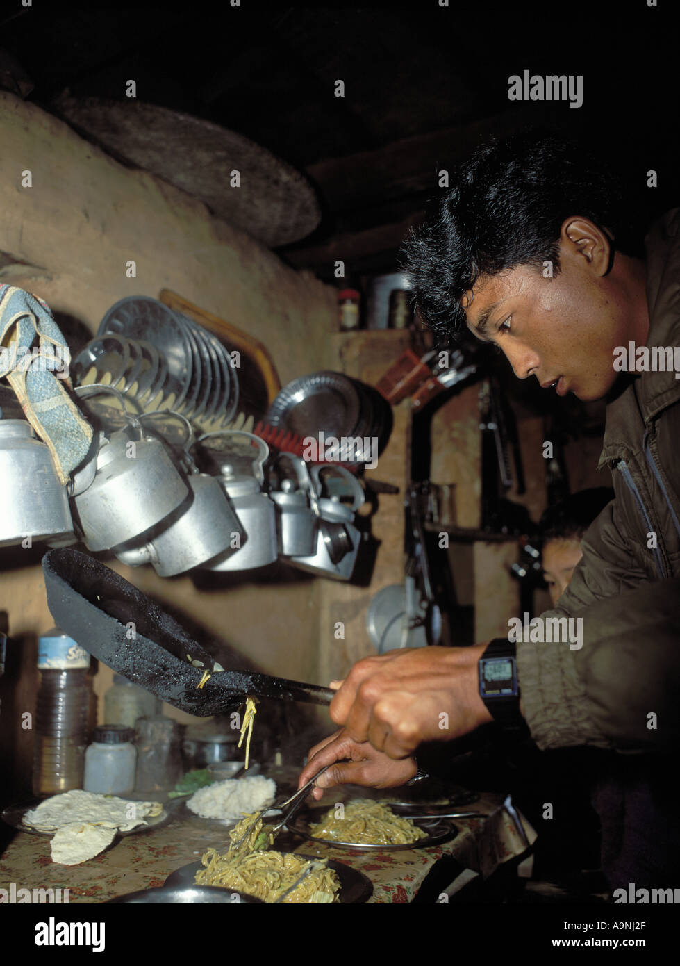 Nepal Trekking Hütte Essenszubereitung Annapurna Circuit, Nepal mit Metall kochen Utensilien und junger nepalesischer Mann Stockfoto