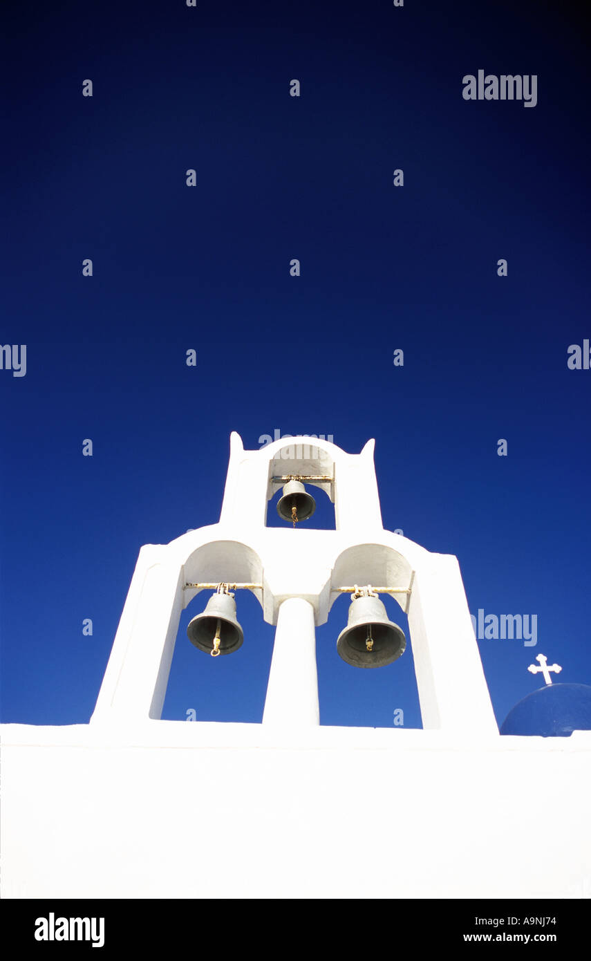 Griechisch-orthodoxe Kirchenglocken in Santorini gegen blauen Himmel mit kleinen Kreuz Stockfoto