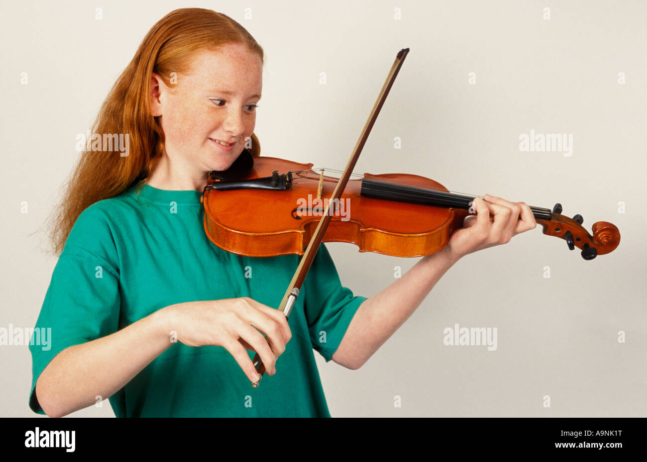 rote Leitung Teenager-Mädchen spielt Geige Stockfoto