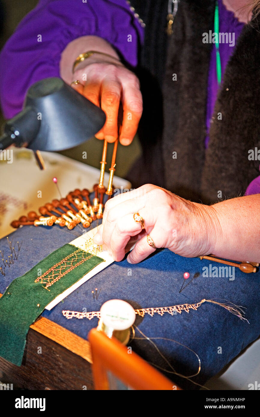 Bild einer älteren Frau Herstellung gold Spitze mit einer Reihe von Spitzen Klöppeln Stockfoto