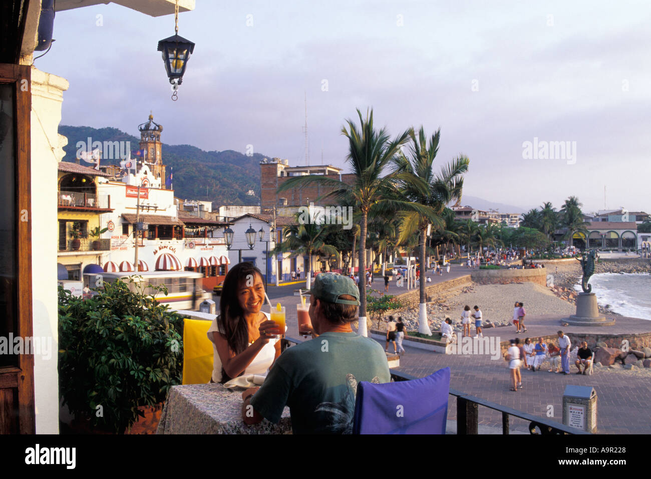 Paar beim Sonnenuntergang Getränke im Restaurant direkt am Meer in Puerto Vallarta Mexiko Stockfoto