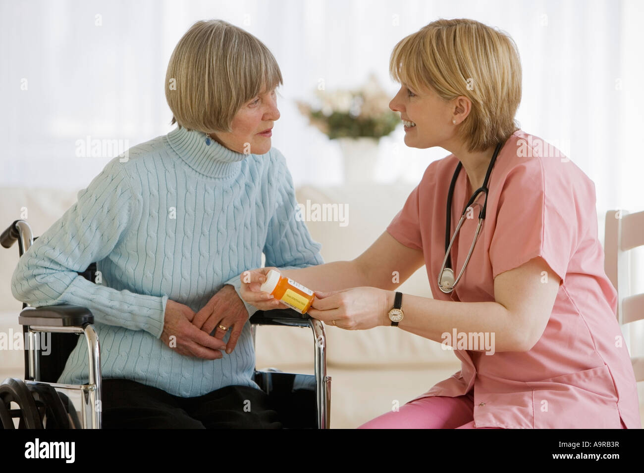Krankenschwester, die Medikation mit senior Frau diskutieren Stockfoto
