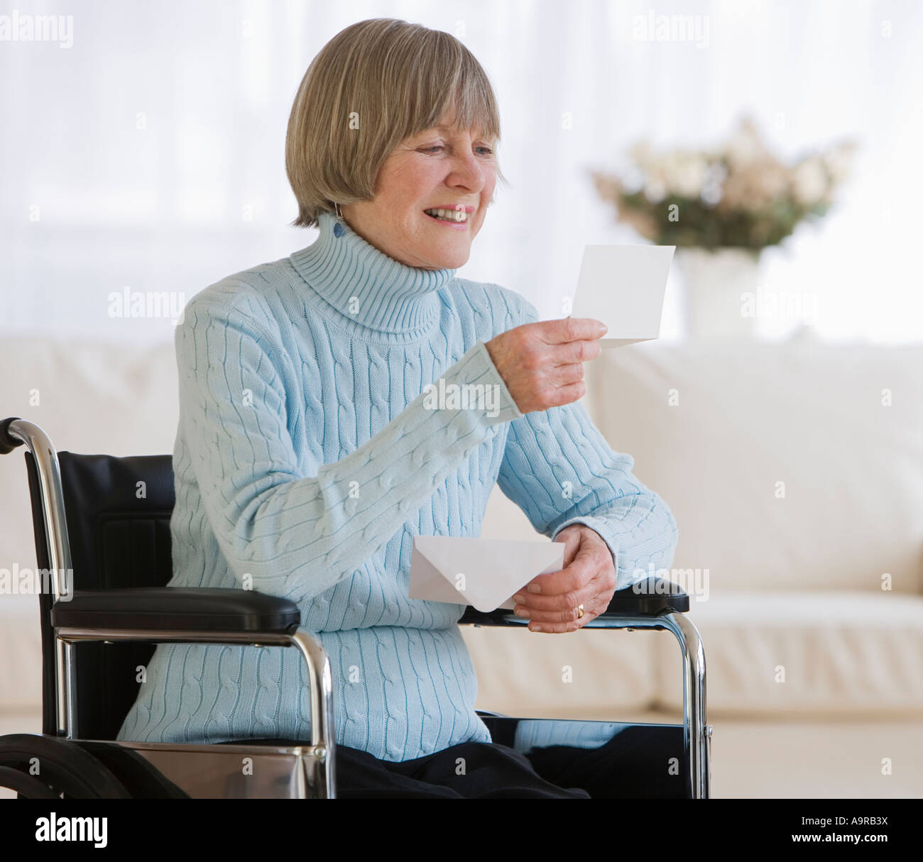 Ältere Frau im Rollstuhl Brief lesen Stockfoto