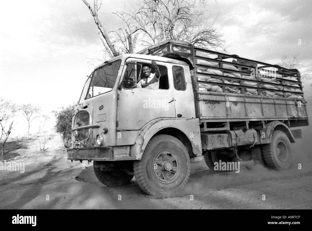 S/W eines winkenden Fahrers in seinem Lastwagen, gefüllt mit Säcken mit Nahrungsmittelhilfe, der in Hungersnot und im Krieg zerrissenen Tigray fuhr. Äthiopien, Afrika Stockfoto