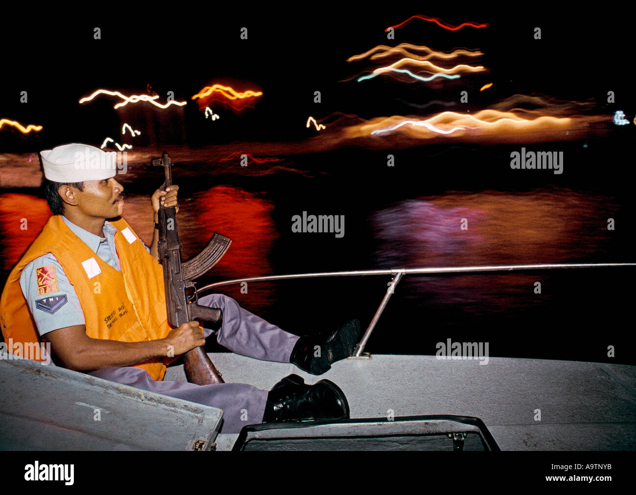 Die Crew sitzt auf dem Bootsdeck mit einem geladenen AK47 parat. Stockfoto