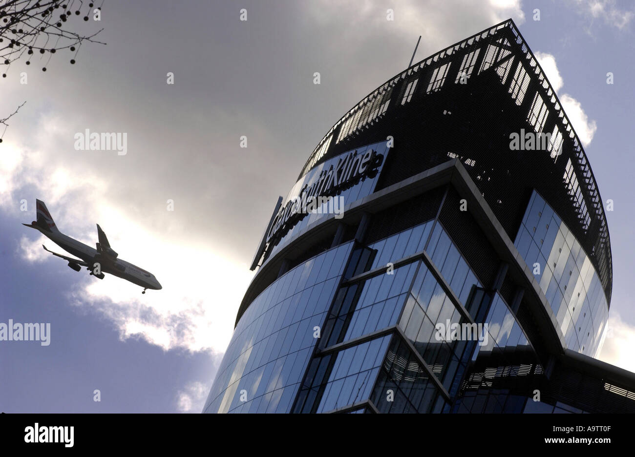 GlaxoSmithKline-HQ in Großbritannien mit einem vorbeifahrenden Flugzeug Stockfoto