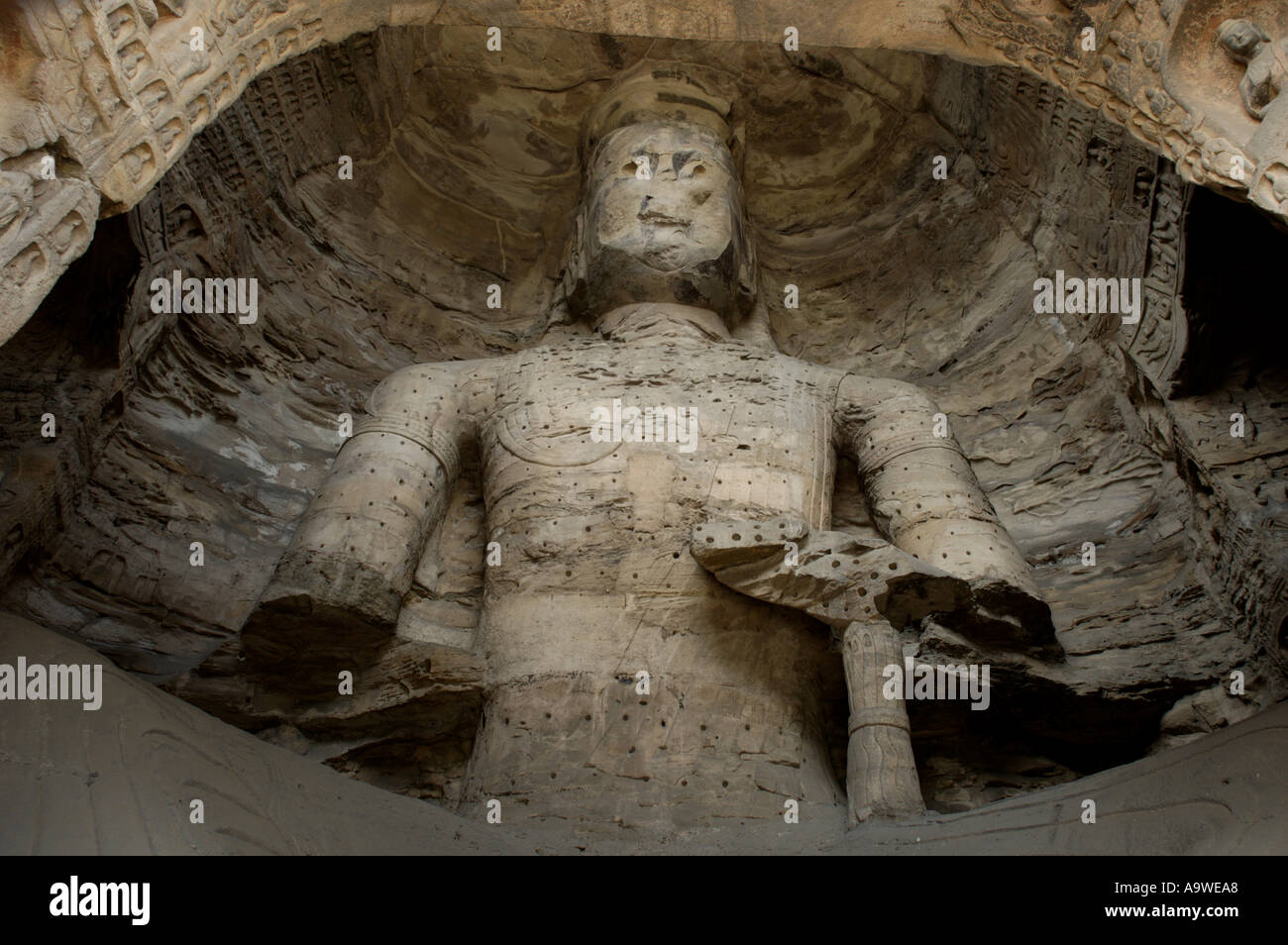 Beschädigte Buddha-Statue geschnitzt in den alten Yungang Grotten, Datong, Shanxi, China. Stockfoto