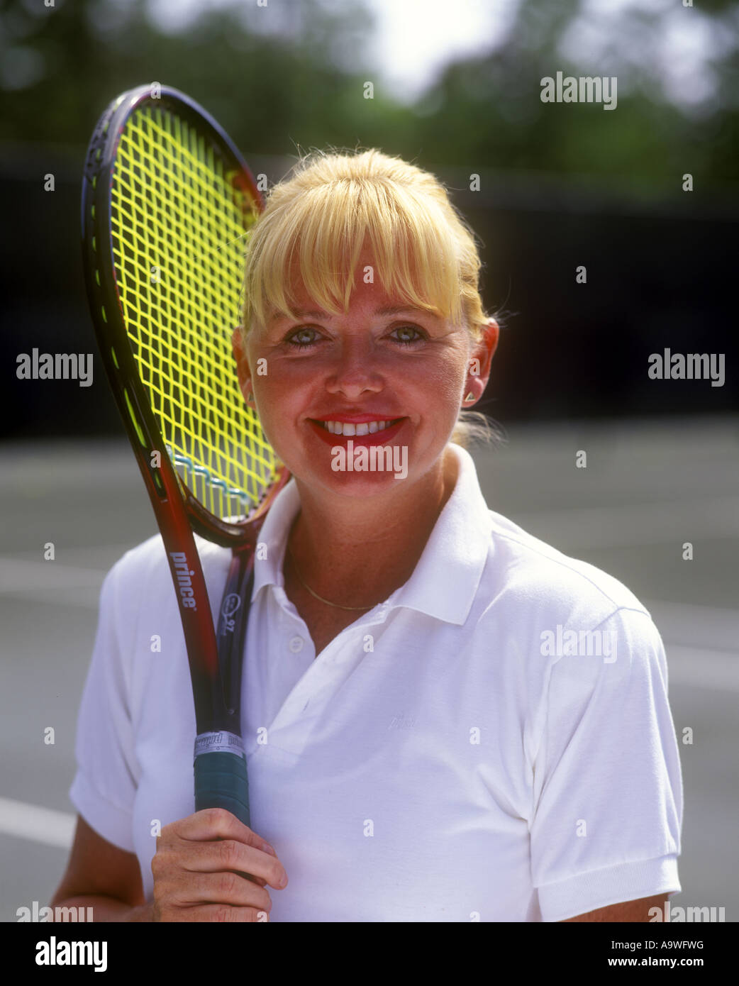 LÄCHELND MITTE FRAU TENNISSPIELER IM ALTER VON Stockfoto