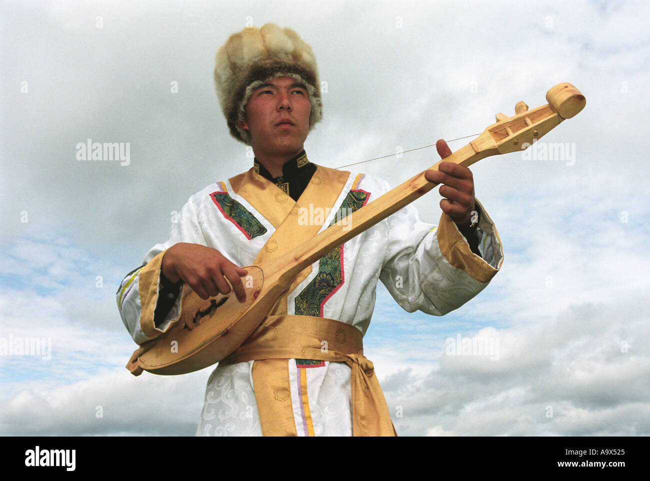 Mann im altaischen Kostüm Nationalmusik Instrument Topshur spielt und singt ein Lied in einzigartiger Weise kehligen Gesang National Stockfoto