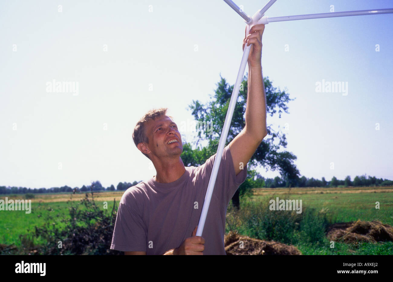 Polen, Uniejow, Mann, hält Zelt Stangen Stockfoto