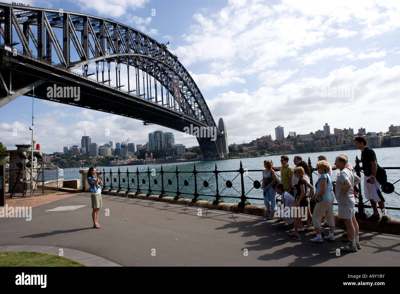 Eine Frau nimmt ein Bild von einer Gruppe von Touristen entlang der Uferpromenade von Sydney in den Rocks Stockfoto