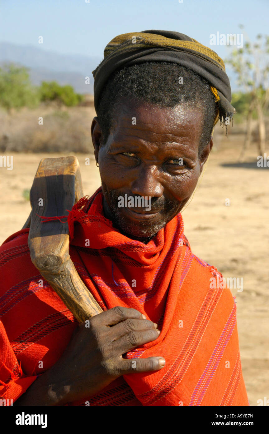 Alter Mann der ethnischen Arbore, gekleidet in einen roten Umhang mit einem hölzernen Werkzeug in der Nähe von Weyto Äthiopien Stockfoto