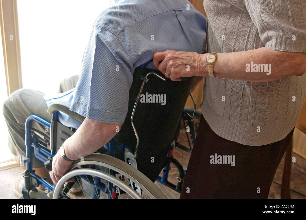 Care Home - alte ältere Frau drücken ein alter Mann im Rollstuhl Stockfoto