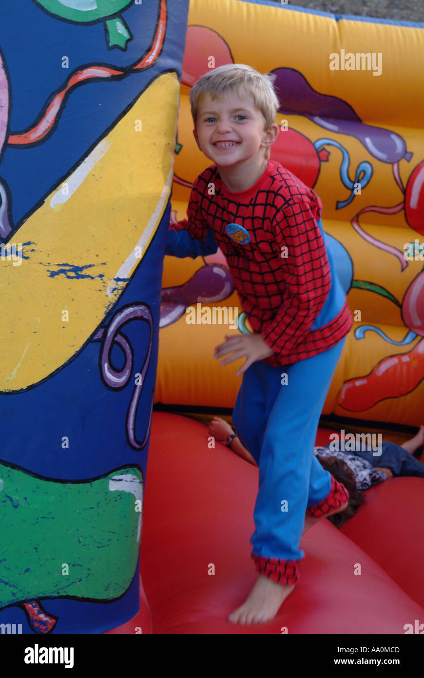 Kleiner Junge springt auf eine Hüpfburg Stockfoto