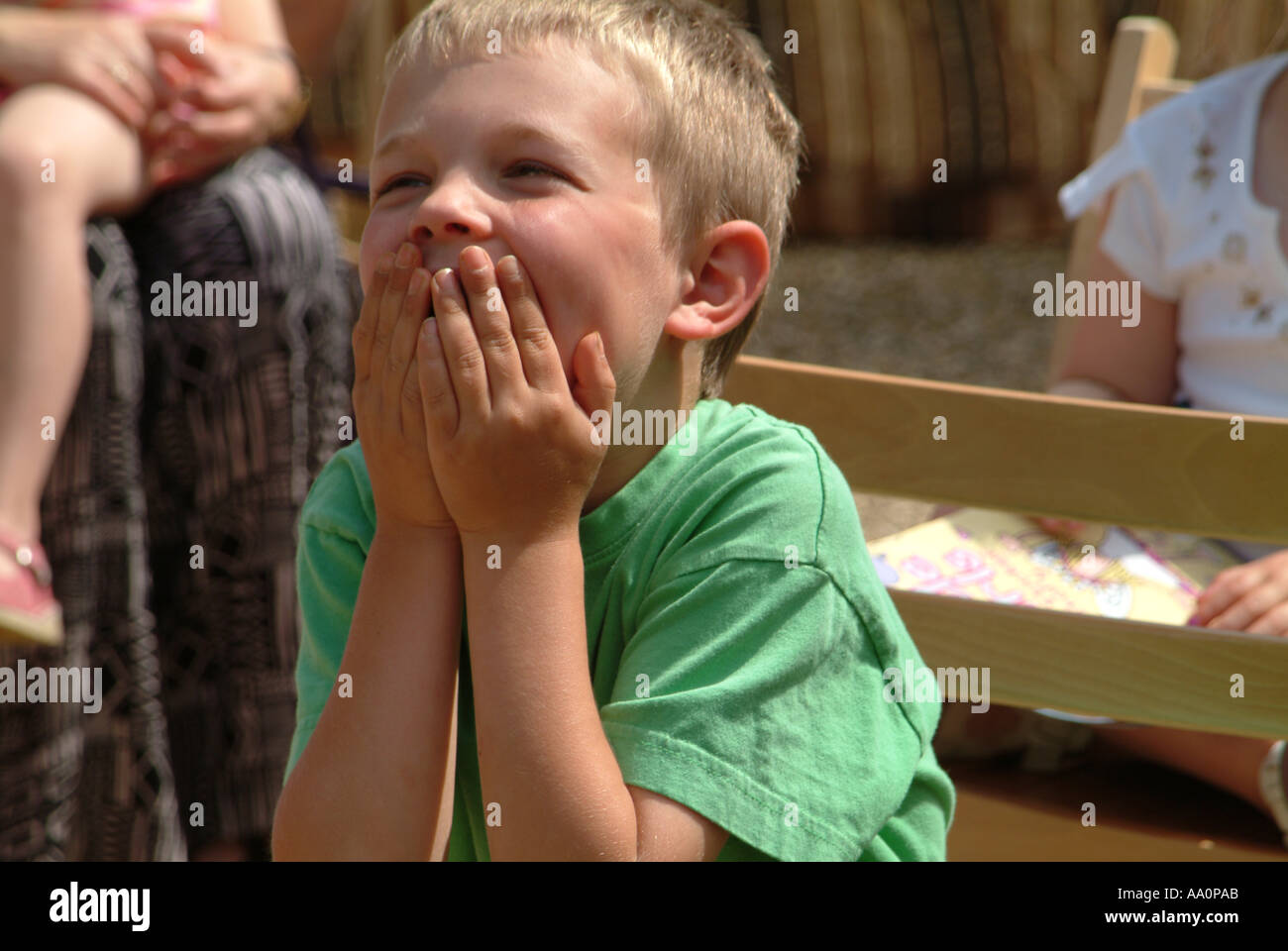 Kleiner Junge mit Hand vor den Mund staunend Stockfoto