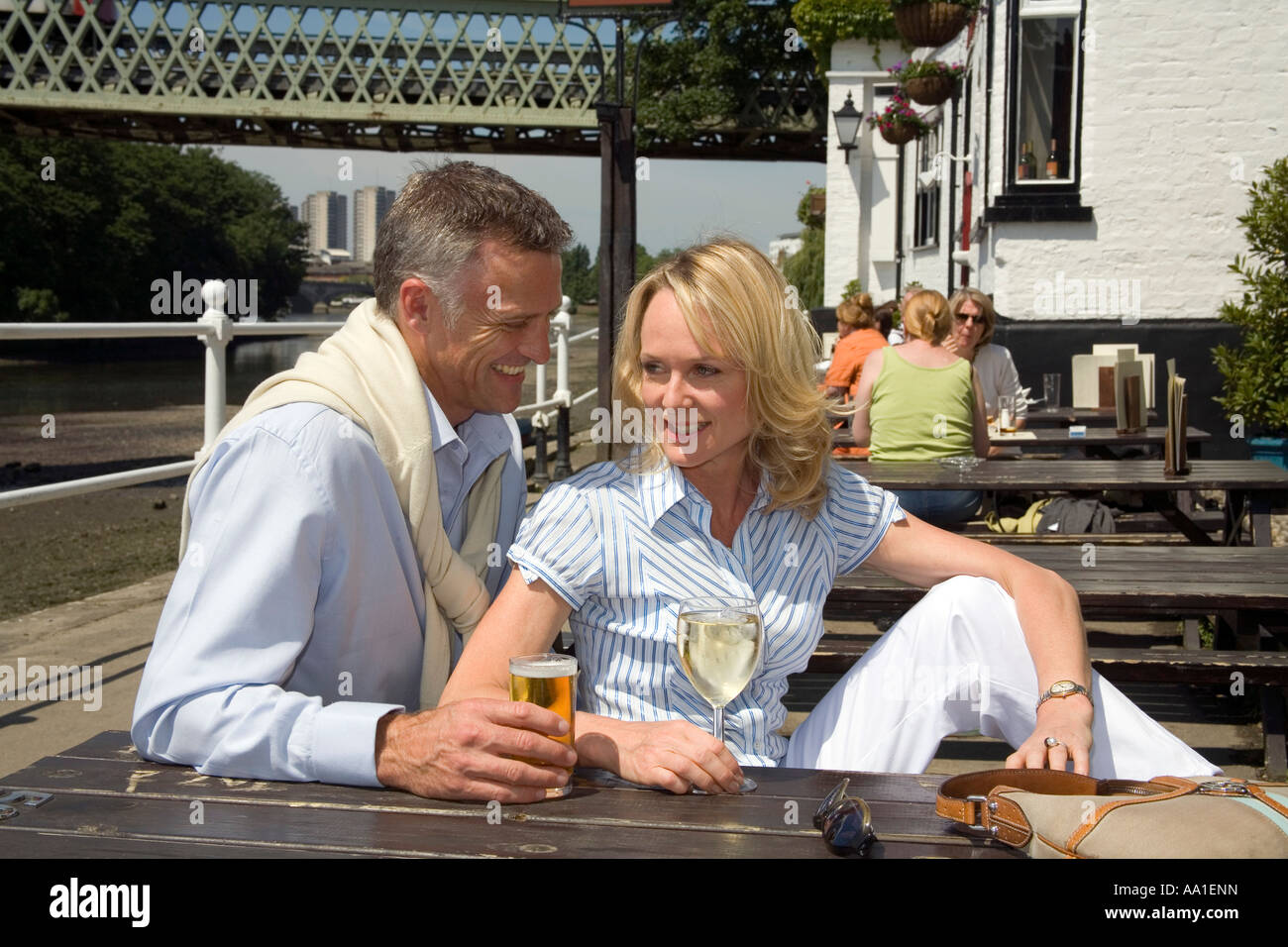 Paar am Strand auf dem Grün außerhalb der Bulls Head Pub Chiswick London Stockfoto