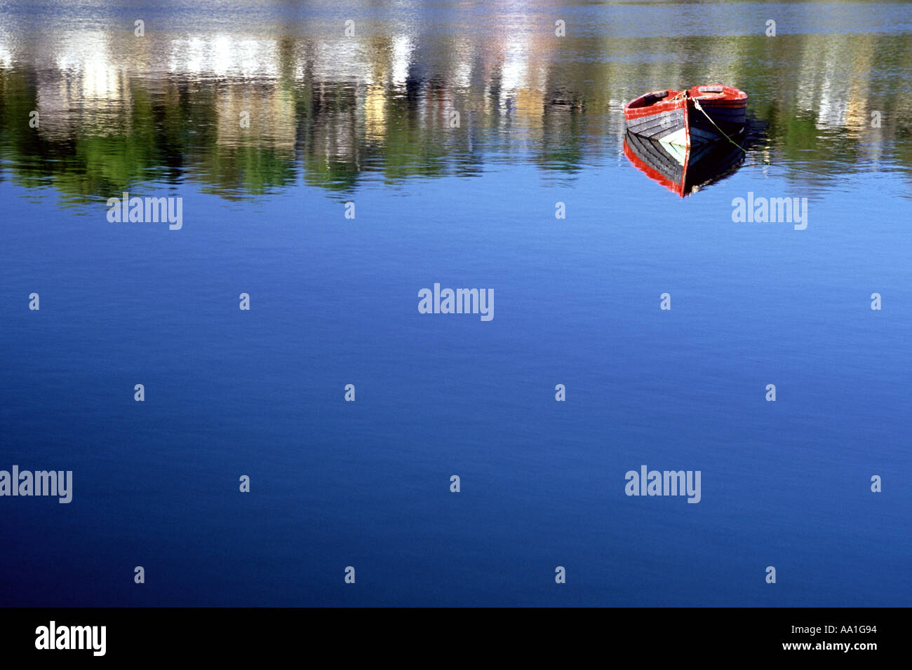 Ein Ruderboot verankert in einem ruhigen Flecken des Wasser im Hafen von Kinsale in County Cork, Irland. Stockfoto