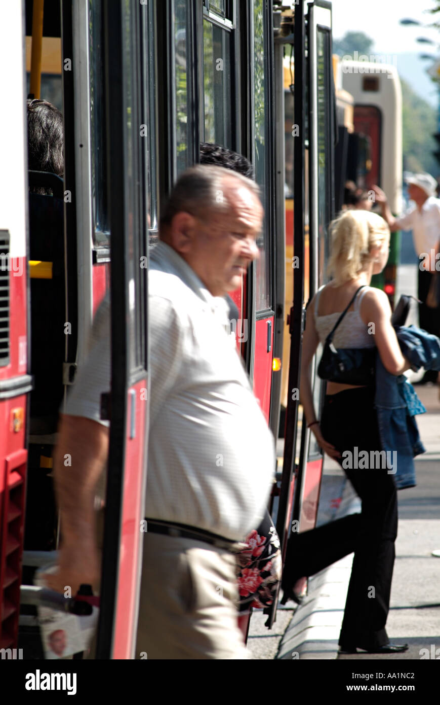 Reifer Übergewicht Mann und eine junge Frau immer aus einem Bus in einer belebten Innenstadt Stockfoto