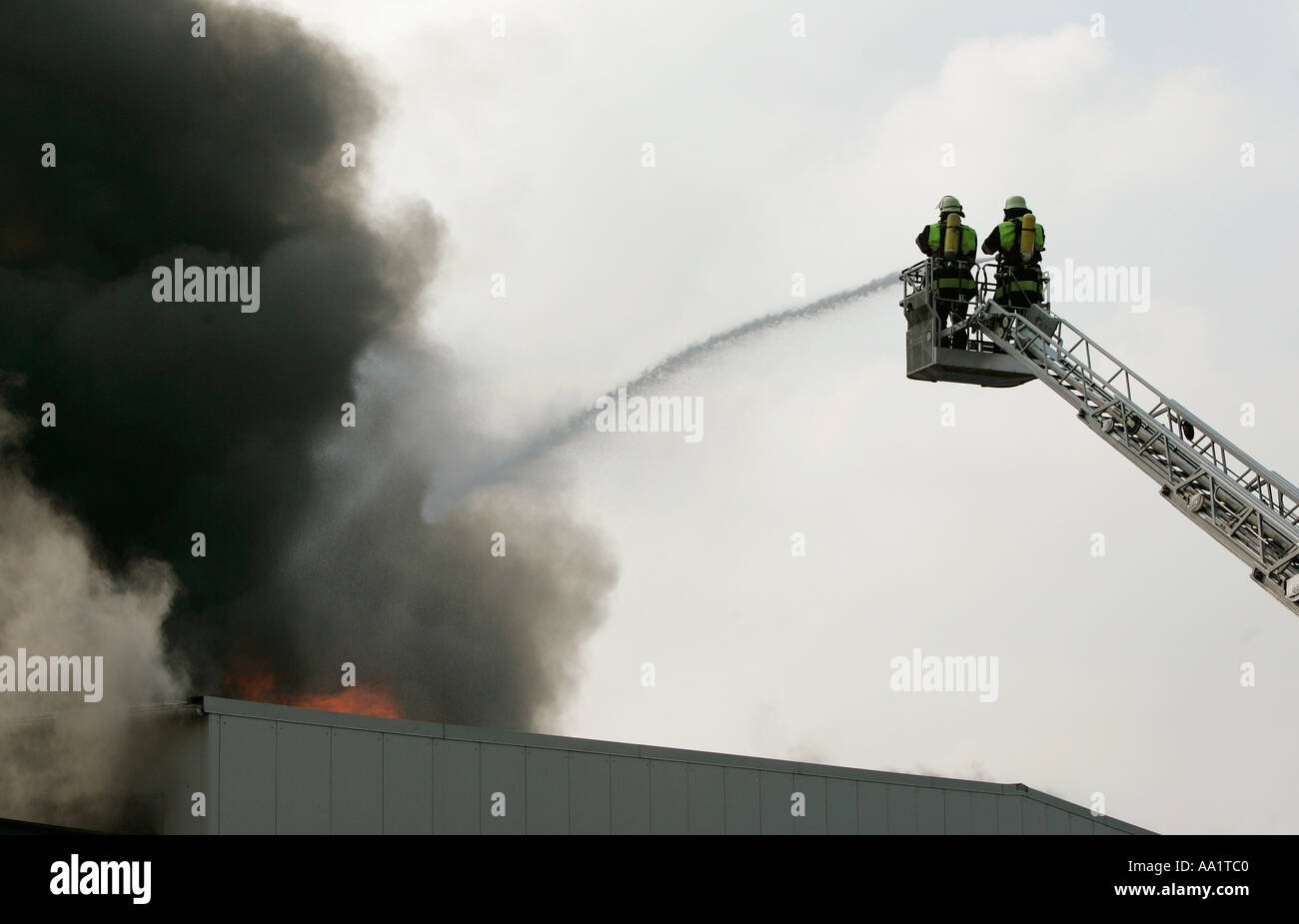 Deutsche Feuerwehr-Männer kämpft ein Feuer in einer Lagerhalle in München Bayern Deutschland Stockfoto