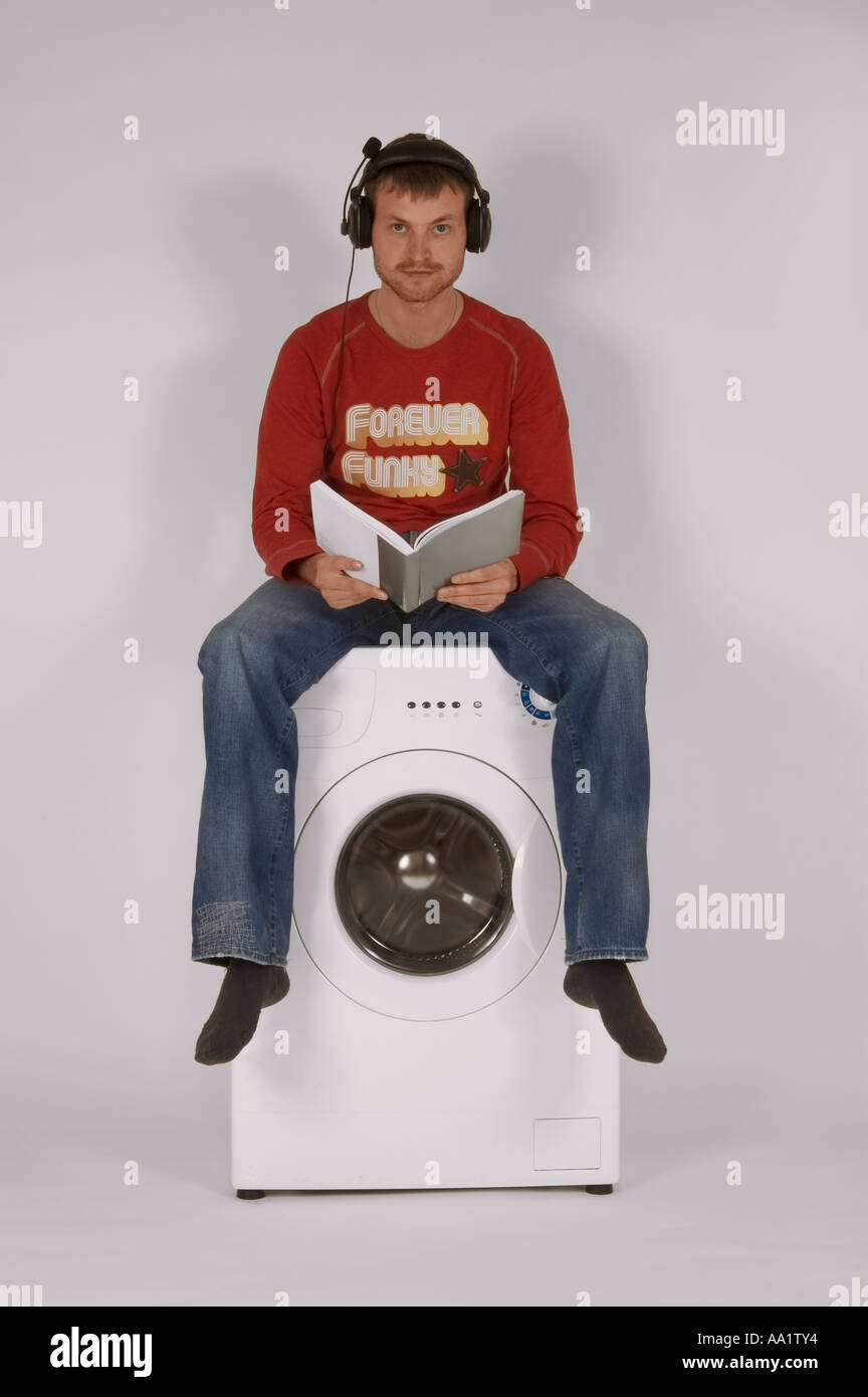 Mann auf der Waschmaschine sitzen und lesen Stockfotografie - Alamy