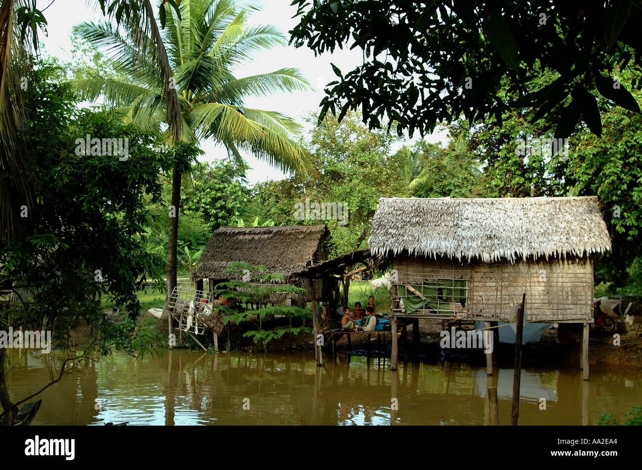 strohgedeckte Haus am Fluss Stockfoto