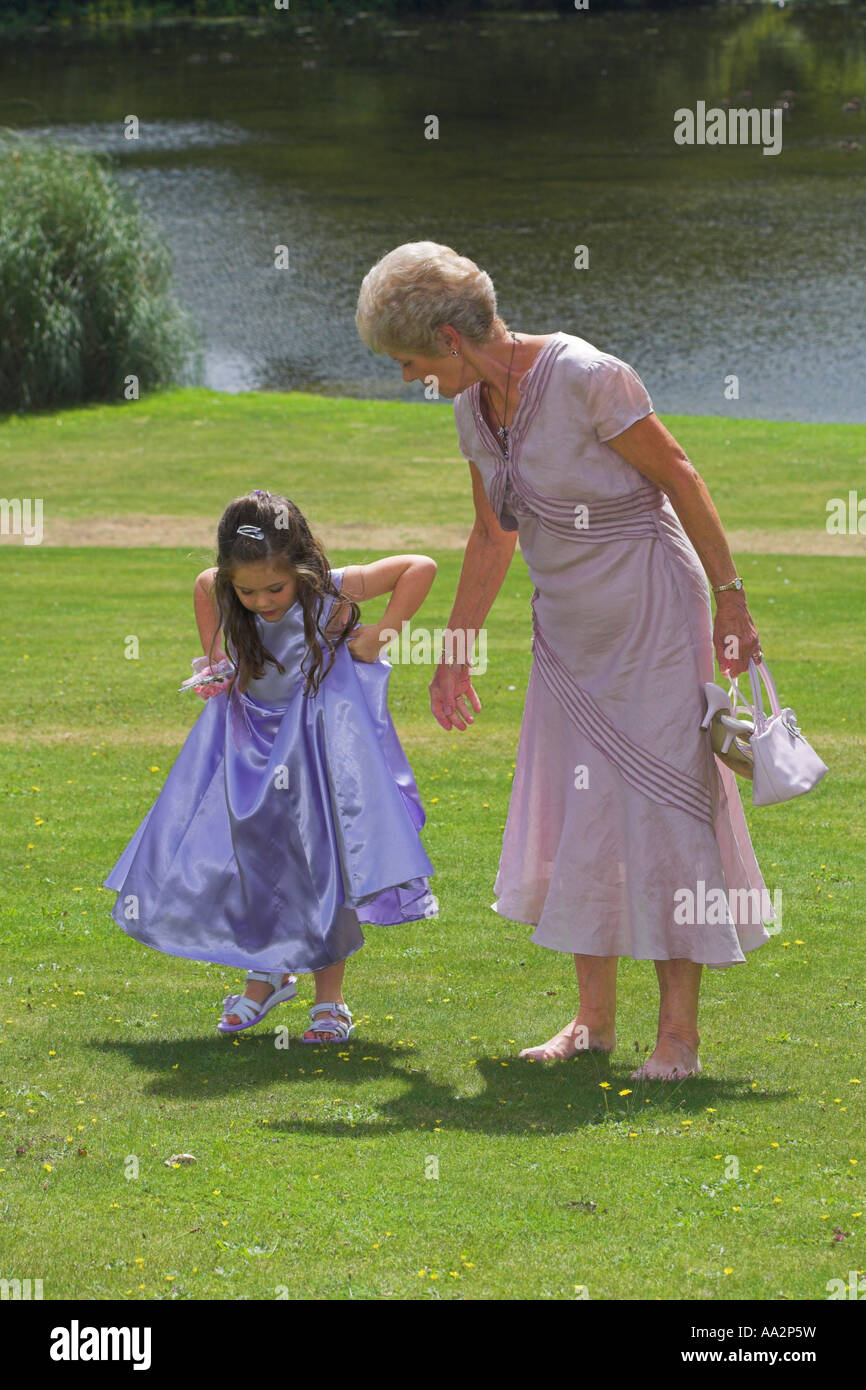 Brautjungfer Kleid anheben, während Großmutter beauftragt Stockfoto