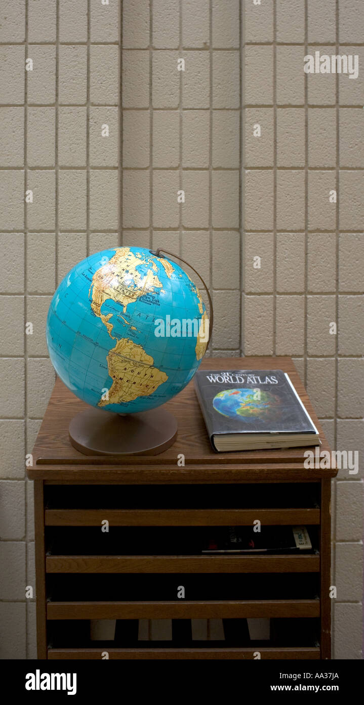 Ein Globus und Welt-Atlas auf einem Tisch in einer Mittelschule Bibliothek in Connecticut USA Stockfoto