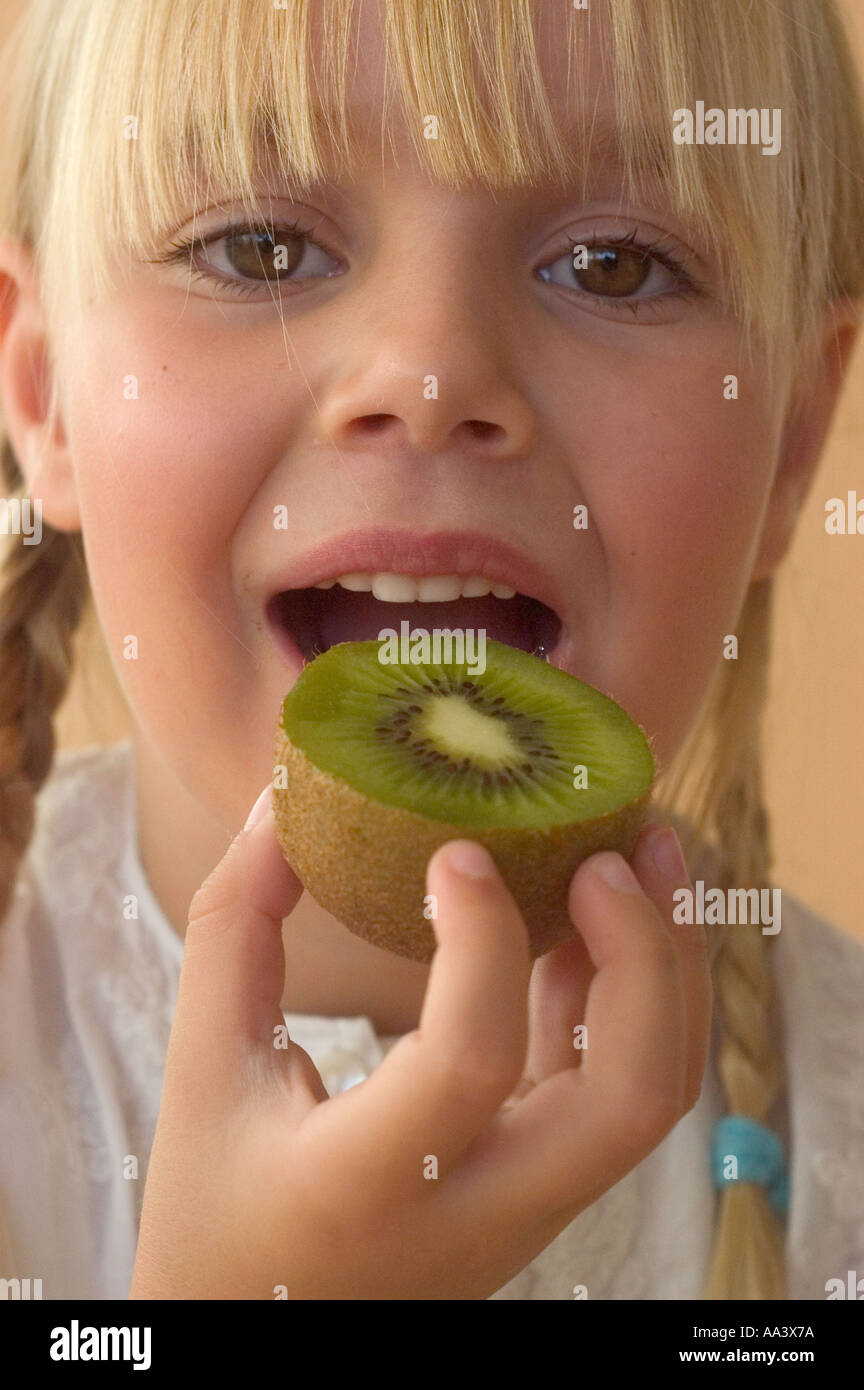 junges Mädchen essen Obst kiwi Stockfoto