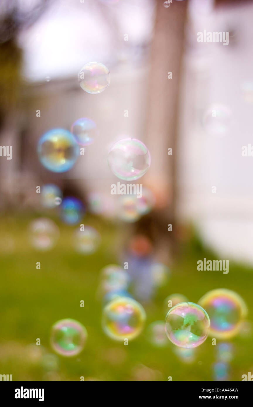 Kind durch laufen, jagen und popping Bubbles tonnenweise Stockfoto