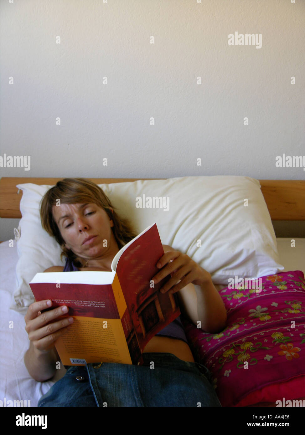 Frau liest ein Buch lag unten auf Bett Stockfoto