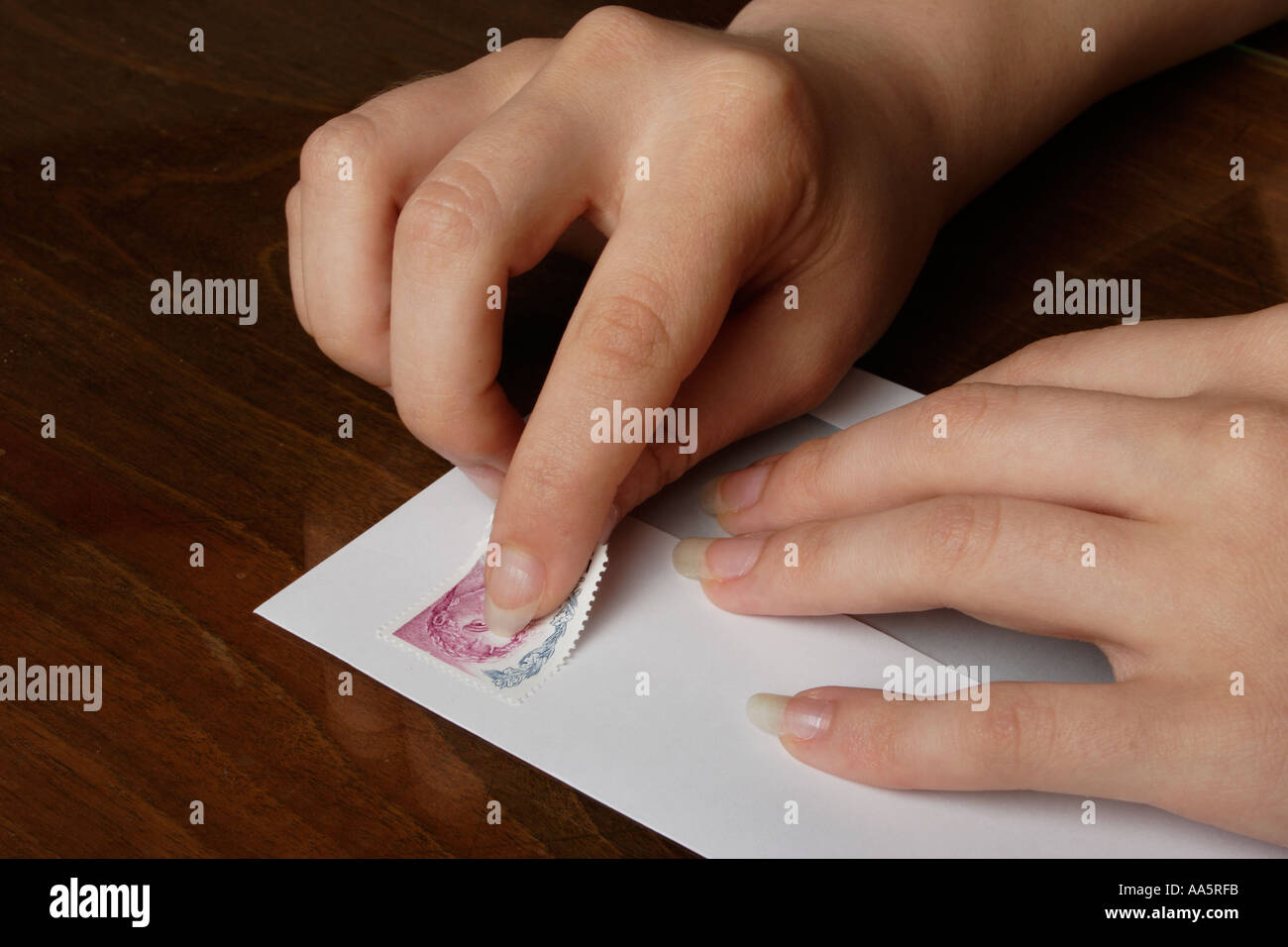 senden Sie Frau Hände Stick Kleber Briefmarke Umschlag Fingerhut Stockfoto