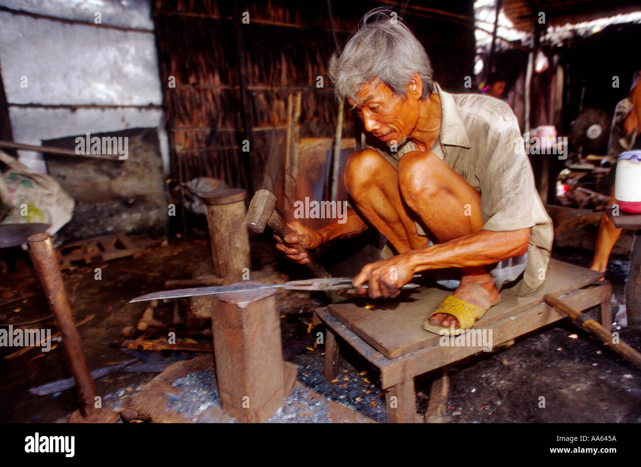 Eine ältere ihre macht ein Messer auf dem Markt einige Zeit später in einem Dorf am Mekong-Delta Vietnam verkauft werden Stockfoto