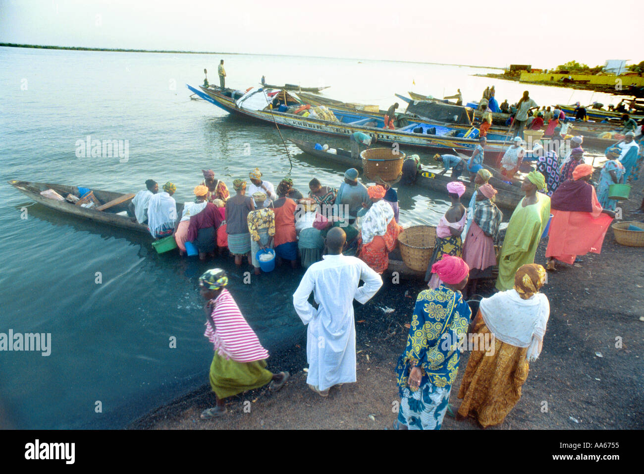 Senegalesische Händler warten auf den einheimischen Fischern in der Stadt West Arican Tage Ernte aus ihrer kleinen Pirogen einbringen Stockfoto