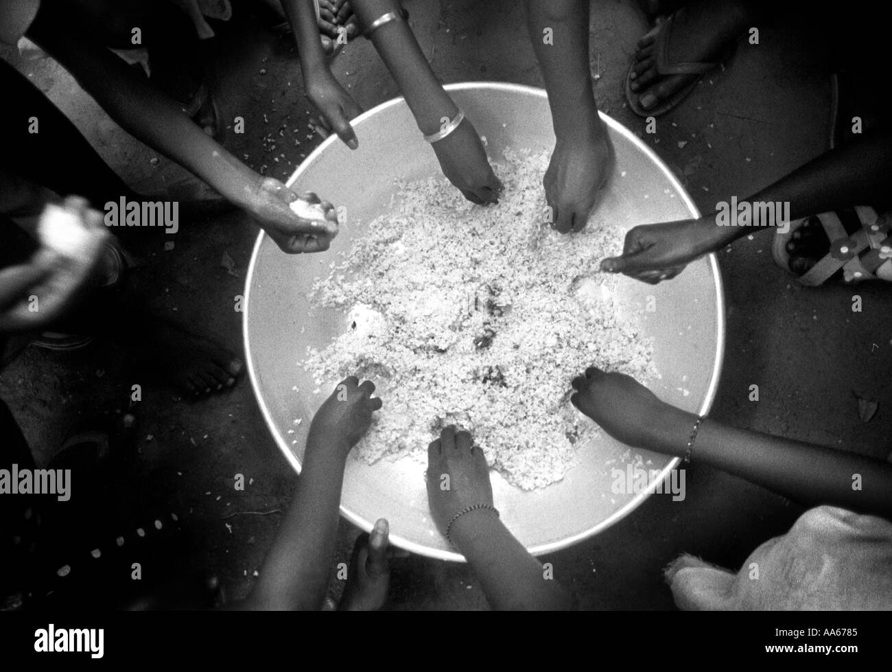Kinder essen Reis zusammen, die vor Ort ist, in Westafrika asiatischen Reis, die verkaufen geerntet worden für weniger als lokale Reis ist Stockfoto