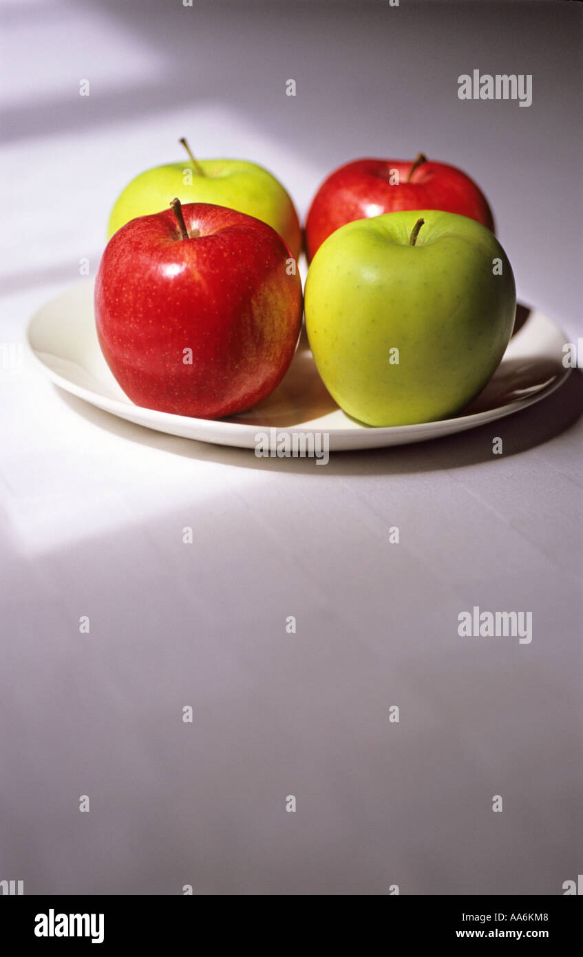 "2 rote Äpfel und 2 grüne Äpfel auf einem Teller" Stockfoto