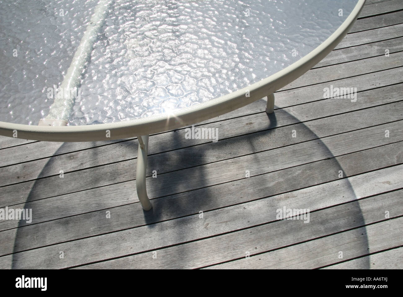 Deck Tisch mit Glas Top zeigt reflektiert Licht und dem leichten Schatten durch das Sonnenlicht durch das Glas Stockfoto