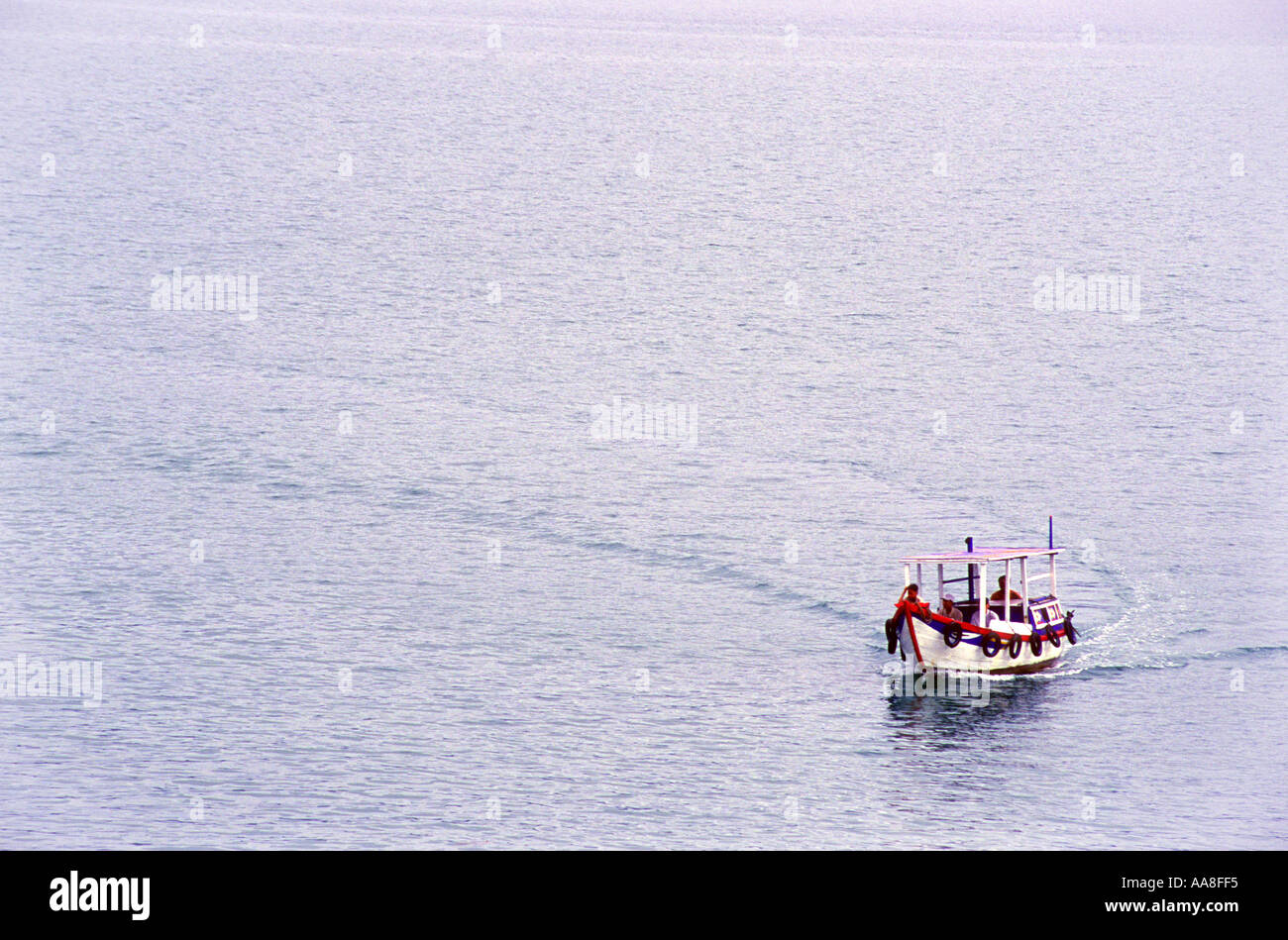 Ein einsamer bunte hölzerne Motorboot macht eine scharfe Kurve auf dem Wasser aus Nha Trang in Vietnam Asien Stockfoto