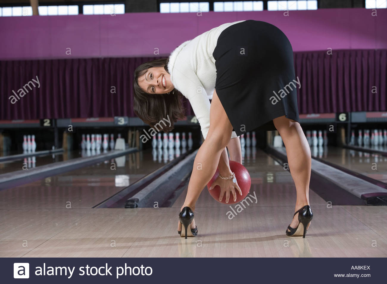 Womanin Highheels bücken mit Bowling Kugel Stockfoto, Bild Womanin Highheels bücken mit Bowling Kugel Stockfoto, Bild