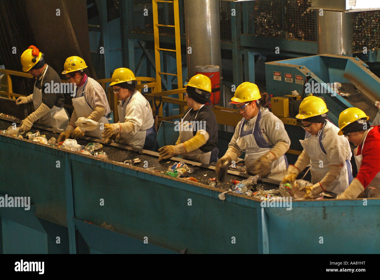Arbeitnehmer sind durch gemischte Material Sortierung und Trennung der Kunststoffe Metalle und Papiere aus dem Papierkorb und Glas Stockfoto