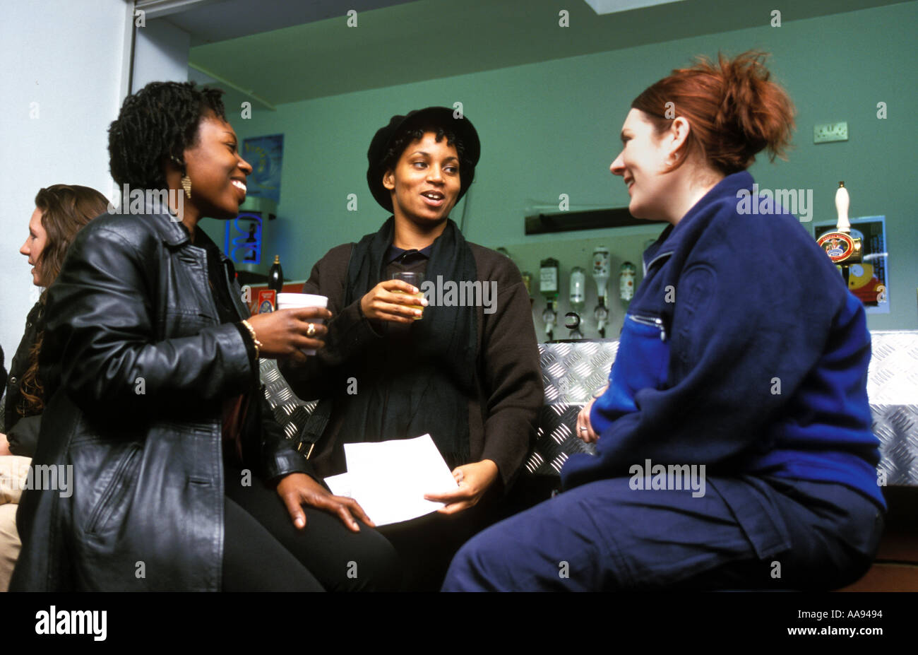 Drei Frauen im Chat bei einem Drink in der Bar der Studentenschaft. Stockfoto