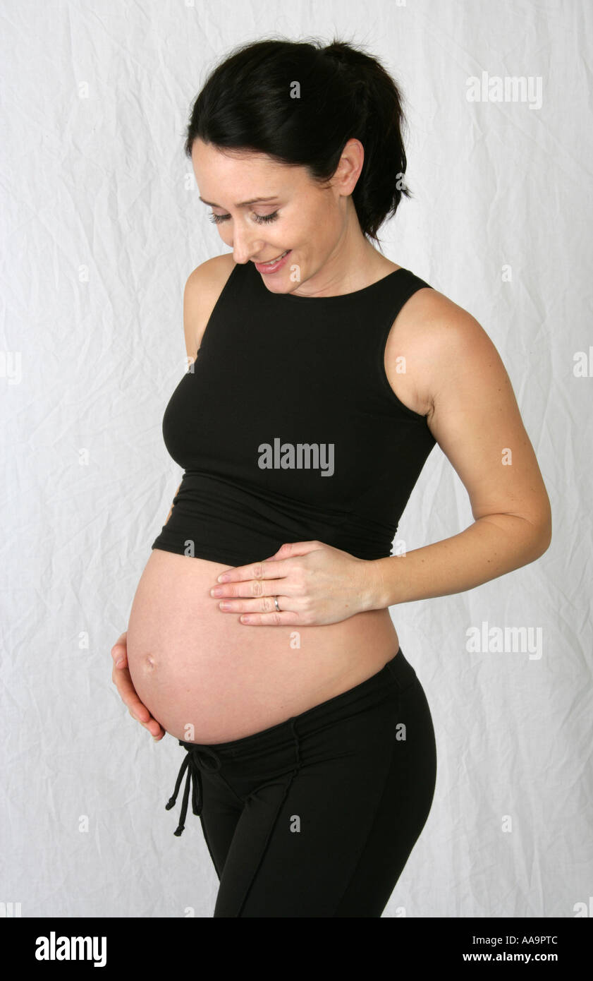 Schwangere Frau trägt eine schwarze Weste Top und schwarze Hose Stockfoto