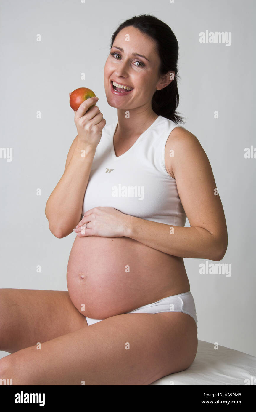 Schwangere Frau einen Apfel essen Stockfoto