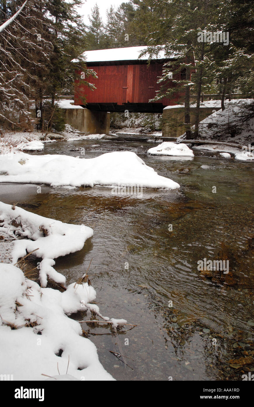 Mit einer überdachten Brücke im Hintergrund fließt das Wasser in einem Fluss im Frühling in Neu-England. Stockfoto