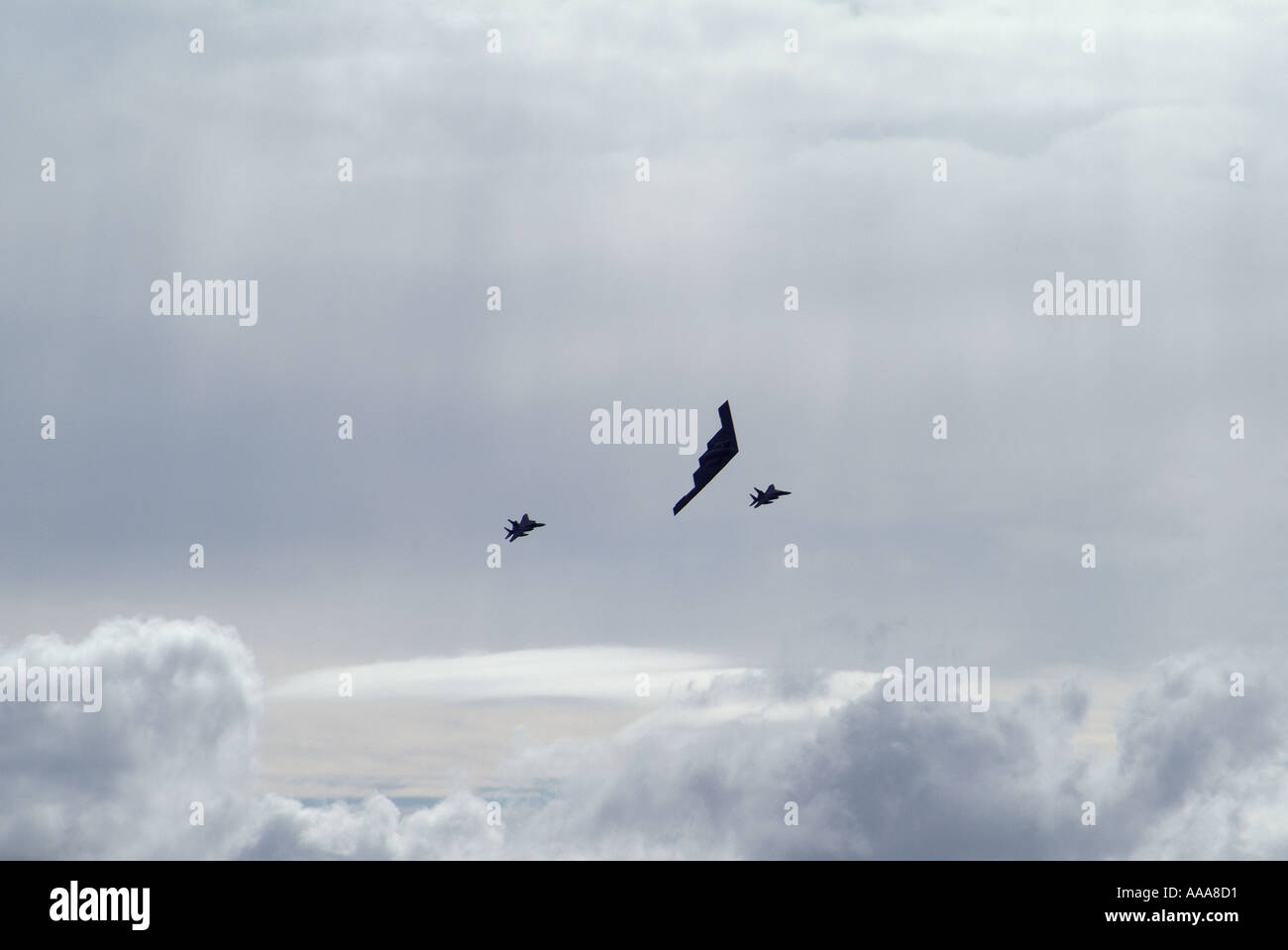 Northrop Grumman B-2A Spirit eskortiert von zwei F-18 Hornets Stockfoto