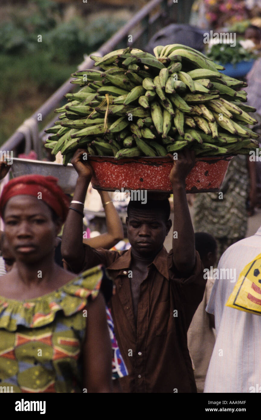 Abidjan, Elfenbeinküste, Westafrika. Mann trägt Wegerich auf Kopf Stockfoto