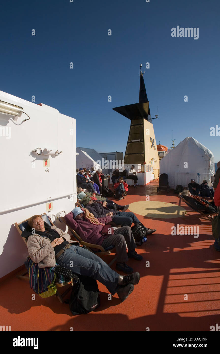 Grönland-Ilulissat-Passagiere an Deck der Arctic Umiaq Line Fähre Segeln Norden von Sisimiut in Morgensonne ruhen. Stockfoto