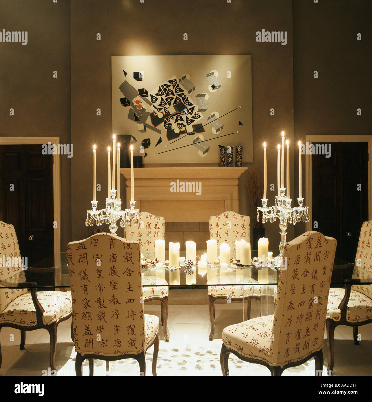 Glas Esstisch Mit Polsterstuhlen Beleuchtet Von Kerzen Und Kunstwerke Uber Kamin Stockfotografie Alamy