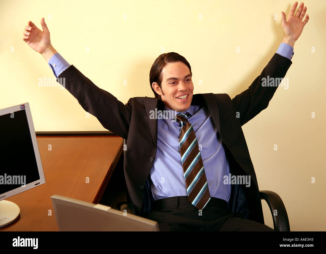 Junger Geschäftsmann lächelnd und Arme in Aufregung Stockfoto