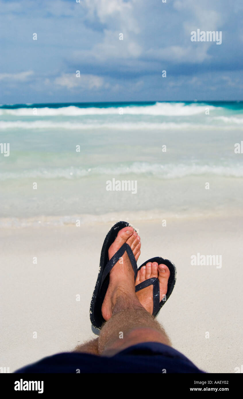 Mans Füße am Strand Stockfoto