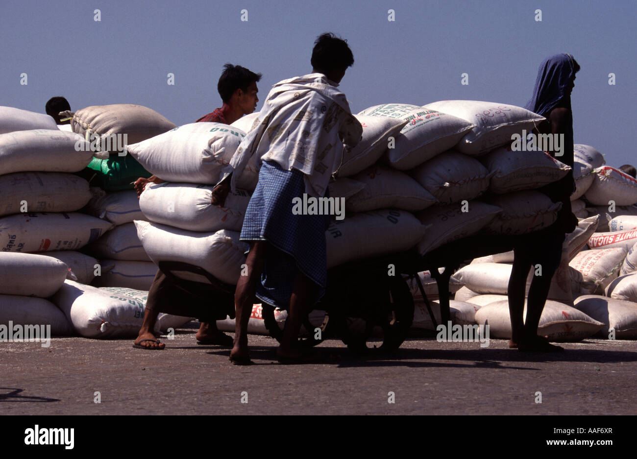 Drei Männer tragen Reis Taschen Mawlamyine Moulmein Myanmar Stockfoto